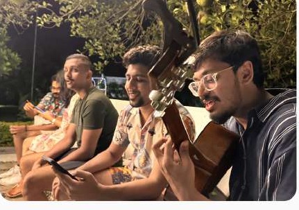 Friends playing guitar in the evening